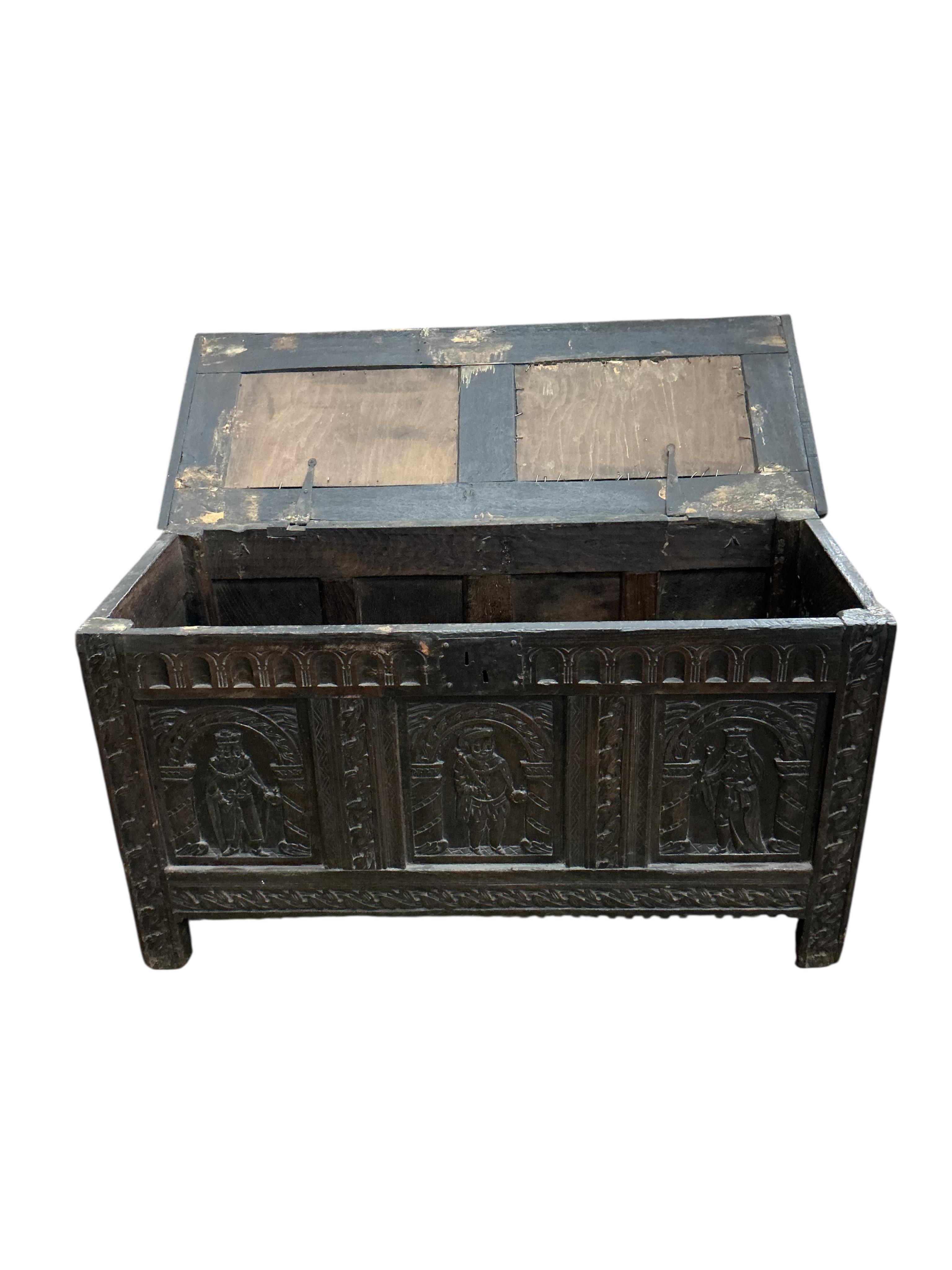 An 18th century oak panelled coffer, later carved, width 116cm, depth 49cm, height 64cm